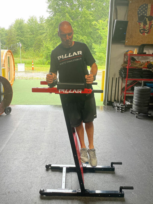 Person using Pillar Vertical Plank system in garage