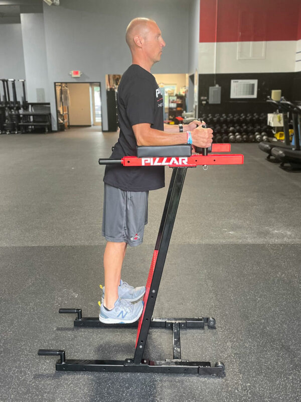 Person using Pillar Vertical Plank system in a gym