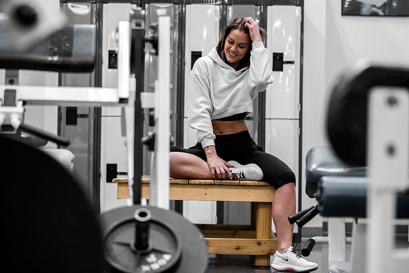 Person sitting on bench in home gym